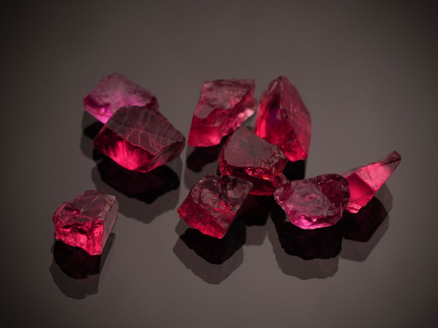 Red ruby gemstones displayed against a dark surface